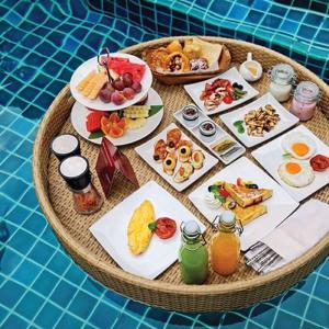 een ronde tafel met ontbijtproducten en drankjes erop bij Riverside French Villa in Thuan An