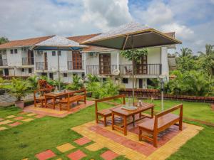 a resort with wooden tables and benches in a yard at Wada Chirebandi in Gimvi