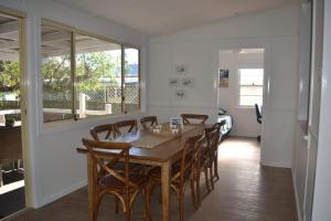 a dining room with a wooden table and chairs at Christina Cottage in South West Rocks