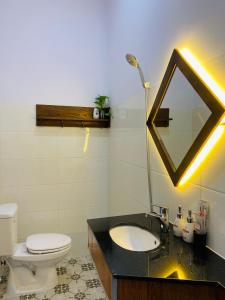 y baño con lavabo, aseo y espejo. en Romo Homestay en Quang Ngai