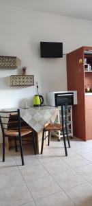 a kitchen with a table and chairs in a room at Faros Apartments in Xerokampos