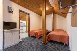 a room with two beds and a flat screen tv at Morena in Klaipėda