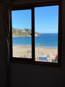 uma janela com vista para a praia e para o oceano em Hostal AGUSTÍN II em Cartagena
