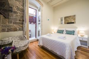 een slaapkamer met een groot bed en een stoel bij Hidden Luxury Residence 2BR with terrace in Split