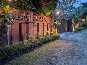 un bâtiment en briques avec un panneau indiquant les jardins en terre cuite dans l'établissement Astuti Gallery Homestay, à Yogyakarta