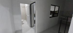 a white bathroom with a mirror and a toilet at LA MEDELLIN HOSTAL in Cartagena de Indias +37 photos