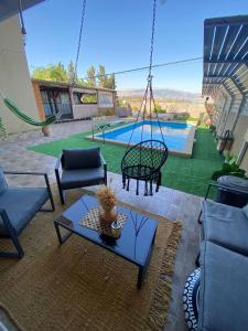a patio with a swing and a pool at חלומות סיגלית בקריית שמונה in Qiryat Shemona