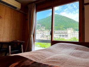 1 dormitorio con cama y ventana grande en Fukiya, en Gero