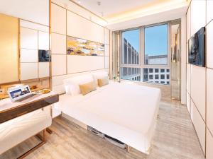 a bedroom with a large white bed and a window at Regala Skycity Hotel in Hong Kong
