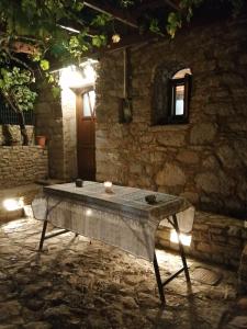 una mesa de piedra frente a un edificio de piedra en ΑΝΑΒΑΤΟΣ ΕΞΟΧΙΚΗ ΚΑΤΟΙΚΙΑ, en Chios