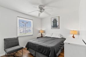 a bedroom with a bed and a chair and a ceiling fan at Shore Oasis in Seaside Heights