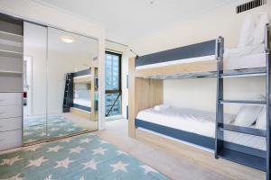 a bedroom with bunk beds and a mirror at 222 Stay on Russell in Melbourne