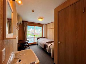 Habitación de hotel con cama y lavabo en Fukiya, en Gero