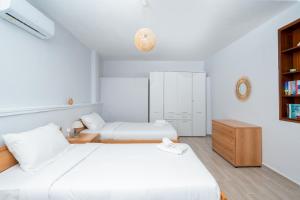 ポルト・ラフティにあるZen Hilltop by A&D Propertiesのベッドルーム(ベッド2台、本棚付)