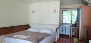 Habitación con cama en habitación con ventana en Tropicana Khophagan Resort Hotel, en Thong Sala