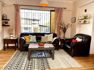 a living room with a leather couch and a table at Saba 301, Subko Coffee, Chapel Road, Bandra West by Connekt Homes in Mumbai