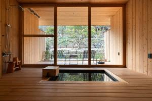 直岛町Naoshima Ryokan Roka的客房设有游泳池和大窗户。