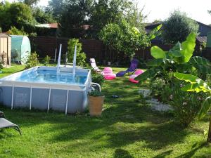 a backyard with a swimming pool in the grass at LA DATCHA in Saujon