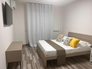 una camera da letto con un letto con cuscini gialli e una TV di City Home 77 a Napoli
