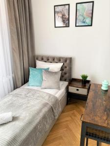 niewielka sypialnia z łóżkiem i drewnianym stołem w obiekcie Apartament ul. Botaniczna w Mielcu