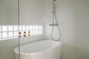 a white bathroom with a shower and a bath tub at Blue Steak Wonder Chatan in Chatan