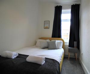 een slaapkamer met een bed met 2 kussens erop bij Westbourne - Spacious 4 bed flat with free parking in Gateshead