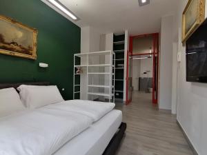 - une chambre avec un lit blanc et un mur vert dans l'établissement Casa Santa Maria 4, à Edolo
