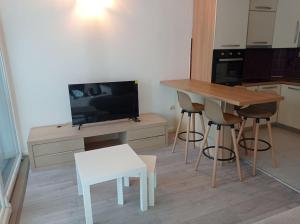 Il comprend une cuisine avec une table et des chaises ainsi qu'une télévision. dans l'établissement M&M Apartment, à Kotor