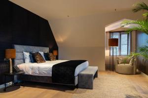 um quarto com uma cama com uma cabeceira preta em Hotel de Boskar Houthalen em Aan de Wolfsberg