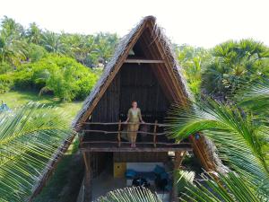 a woman standing in a thatch roof house at Elements Beach & Nature Resort in Kalpitiya