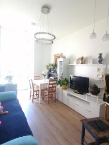 een woonkamer met een bank en een tafel met een tv bij Inmejorable en el Puerto Deportivo a 1 minuto de la playa. Pleno centro in Gijón