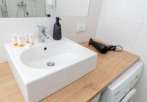 a bathroom with a white sink on a wooden counter at CITYSTAY Starówka Apartament in Gdańsk