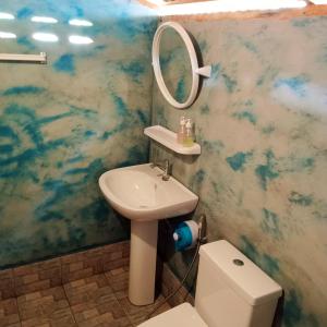 een badkamer met een wastafel, een spiegel en een toilet bij New Andaman Bay Bungalow in Koh Lanta