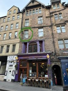 a building with a store with chairs in front of it at Bailie Royal Mile Apartment in Edinburgh