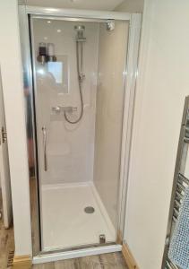 a shower with a glass door in a bathroom at The Studio in Farmborough