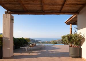 a patio with two benches and a view of the ocean at Sunrise Villa, a Secluded Gem in South Crete, By ThinkVilla in Marioú