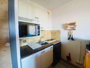 a small kitchen with a sink and a microwave at Les Orres 1650: Centre Station avec garage in Les Orres