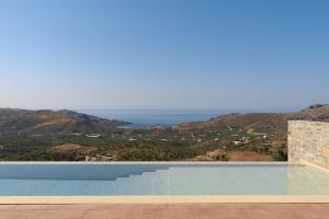 a swimming pool with a view of the ocean at Sunrise Villa, a Secluded Gem in South Crete, By ThinkVilla in Marioú