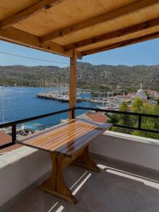 una mesa de madera en un balcón con vistas al agua en Melisa Hotel, en Bozburun