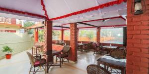 a patio with tables and chairs and a brick wall at Hotel Moonlight, Kovalam, Kerala in Kovalam