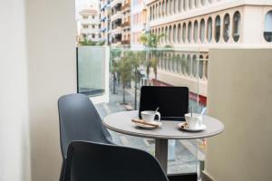 a table and chairs with a laptop on a balcony at Hotel Adonis Capital in Santa Cruz de Tenerife +18 photos