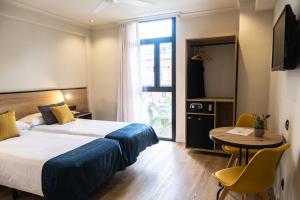 a hotel room with a bed and a table and a window at Hotel Adonis Capital in Santa Cruz de Tenerife