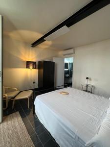 カステル・ヴォルトゥルノにあるBeach Suites - by Lido Scalzoneのベッドルーム(大きな白いベッド1台、椅子付)