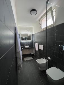 カステル・ヴォルトゥルノにあるBeach Suites - by Lido Scalzoneのバスルーム(洗面台、トイレ付)、窓が備わります。