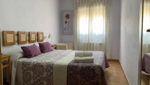 um quarto com uma cama grande e almofadas roxas em Apartamentos Casa Lola rodeados de montañas y rios em Beceite