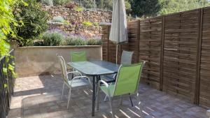 een tafel en stoelen op een patio met een hek bij Apartamentos Casa Lola rodeados de montañas y rios in Beceite
