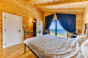 sypialnia z łóżkiem z niebieskimi zasłonami i oknem w obiekcie Olive Hills Holiday homes w Barze