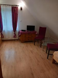 a living room with a table and chairs and a window at Strażnica Komtura in Mikołajki