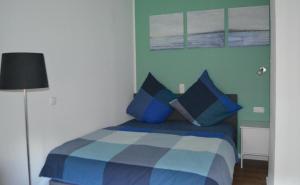 - une chambre avec un lit bleu et des oreillers bleus dans l'établissement Brigg im Schiffehaus, à Wangerland