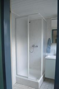 La salle de bains est pourvue d'une douche avec une porte en verre. dans l'établissement Brigg im Schiffehaus, à Wangerland